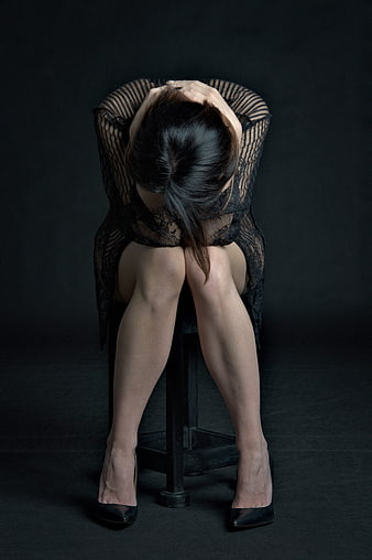 Emotional Portrait of Woman Sitting with Head in Hands