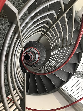 Top-down view of modern spiral staircase with red railing