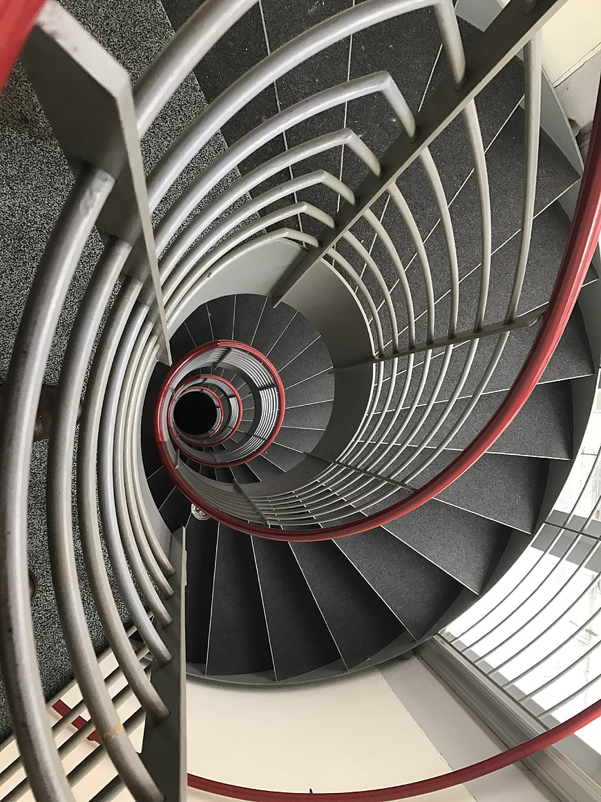 Top-down view of modern spiral staircase with red railing