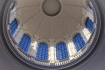 Symmetrical view of a white architectural dome with blue glass windows