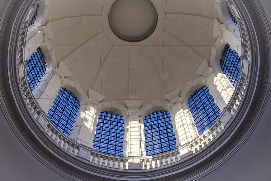Symmetrical view of a white architectural dome with blue glass windows