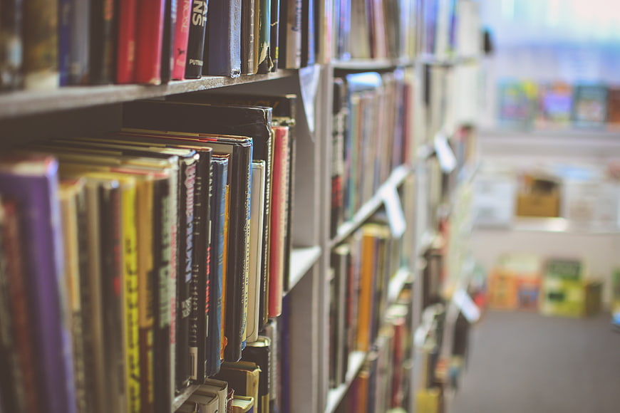 Close-up of colorful books on library shelves with blurred background