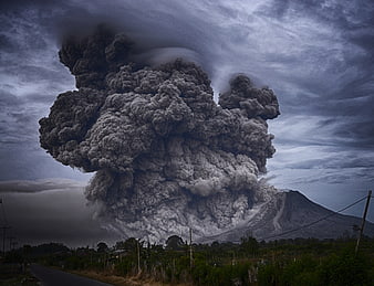 Massive volcanic eruption plume rising over rural landscape
