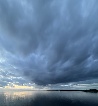 Dramatic Storm Clouds Over Calm Ocean at Sunset