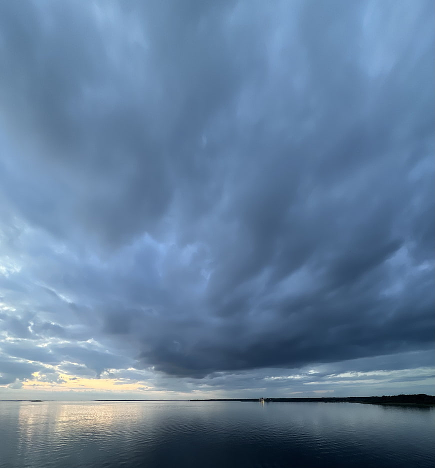 Dramatic Storm Clouds Over Calm Ocean at Sunset