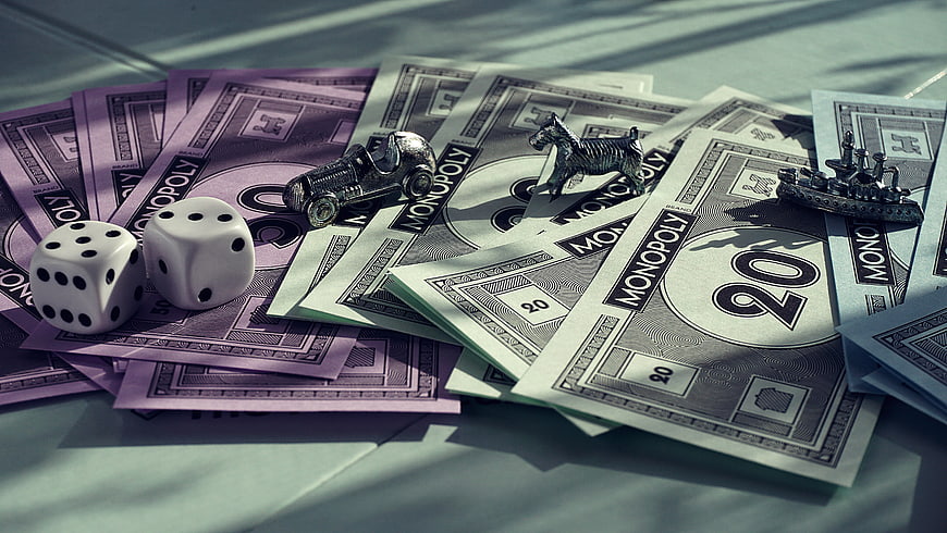 Monopoly money, dice, and game pieces on a table