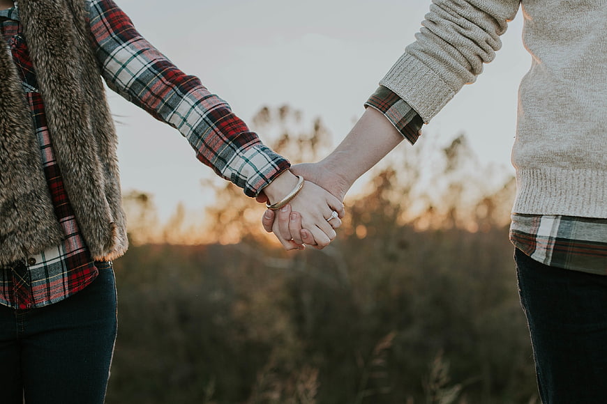 Couple Holding Hands in Plaid Shirts at Sunset