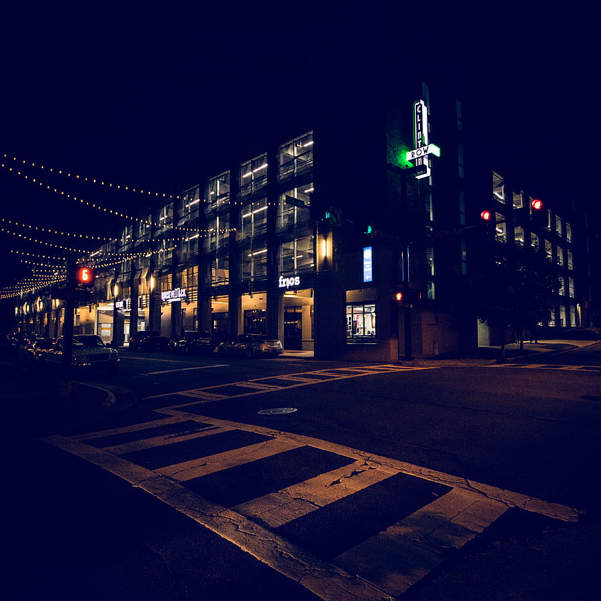 Nighttime Urban Street Scene with Crosswalk and Neon Signs