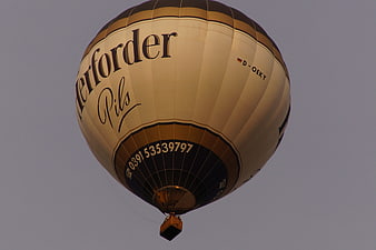 Hot Air Balloon with Branding Against Gray Sky