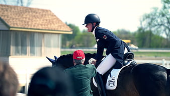 Equestrian Rider Smiling While Being Assisted on Horse