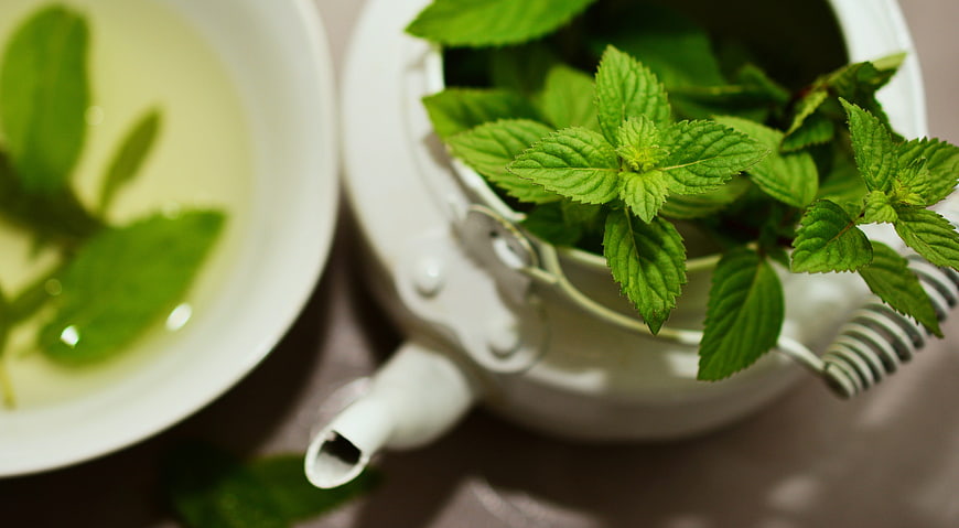 Fresh Mint Leaves in White Teapot and Cup of Tea