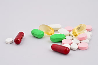 Assorted colorful pills and capsules on white background