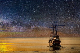 Sailing ship under starry night sky with Milky Way