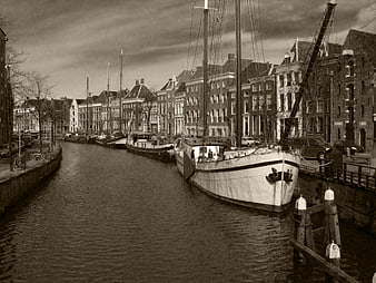 Vintage Sepia Canal Scene with Sailboats and Dutch Architecture