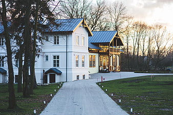 White luxury villa with blue roof and gravel driveway