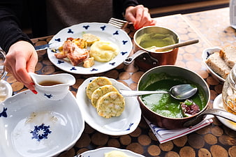 Traditional Czech meal with green soup and pancakes on wooden table