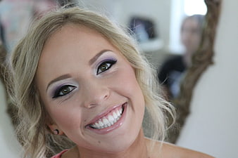 Smiling Blonde Woman with Purple Eye Makeup Portrait