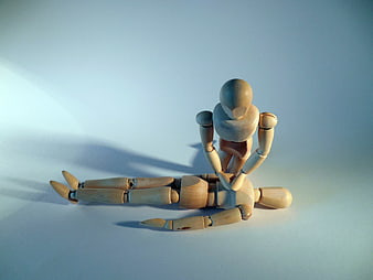 Wooden mannequins performing CPR on a blue background