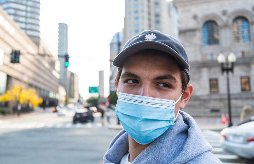 Young man wearing face mask on city street