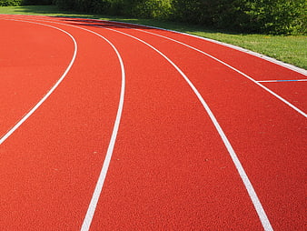 Red running track with white lane lines curving through a stadium