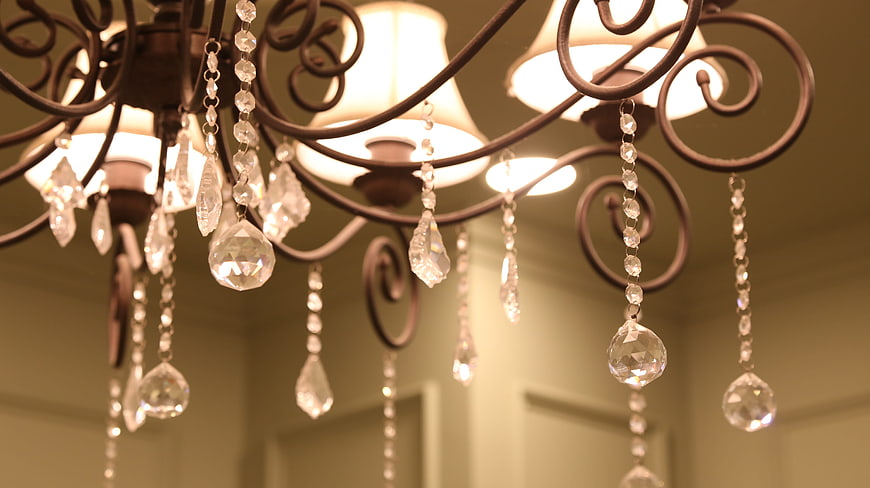 Close-up of ornate wrought iron chandelier with crystal pendants