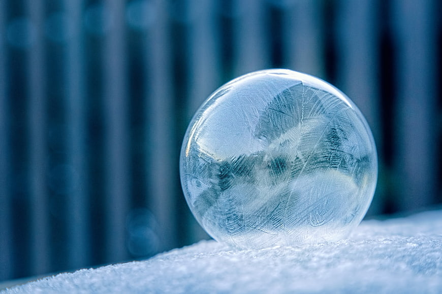 Frozen Ice Sphere on Snow with Intricate Frost Patterns