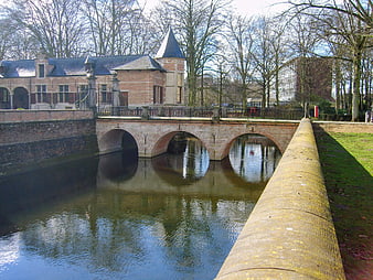 Historic brick bridge over canal with castle in Antwerp