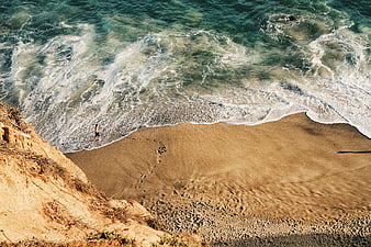 Aerial View of Person Walking on Sandy Beach with Ocean Waves