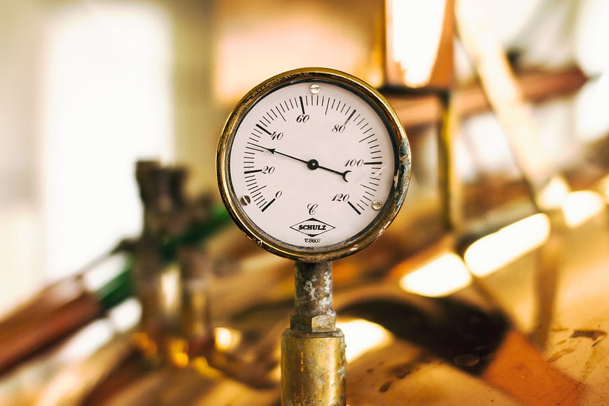 Close-up of vintage industrial pressure gauge on brass pipe
