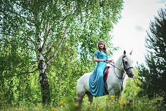 Woman in Blue Dress Riding White Horse in Forest