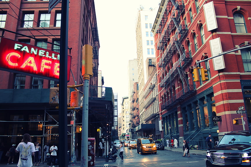 Urban Street Scene with Neon Cafe Sign and Yellow Taxi
