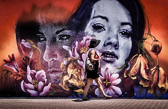 Woman walking past large colorful street art mural with flowers