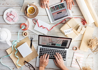 Overhead Flat Lay of Woman Working on Laptop with Gift Wrapping Supplies