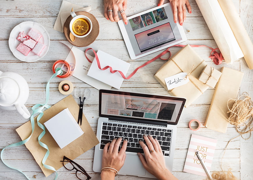 Overhead Flat Lay of Woman Working on Laptop with Gift Wrapping Supplies