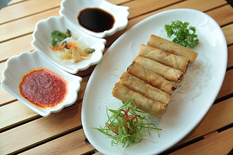 Asian Spring Rolls With Dipping Sauces On White Plate