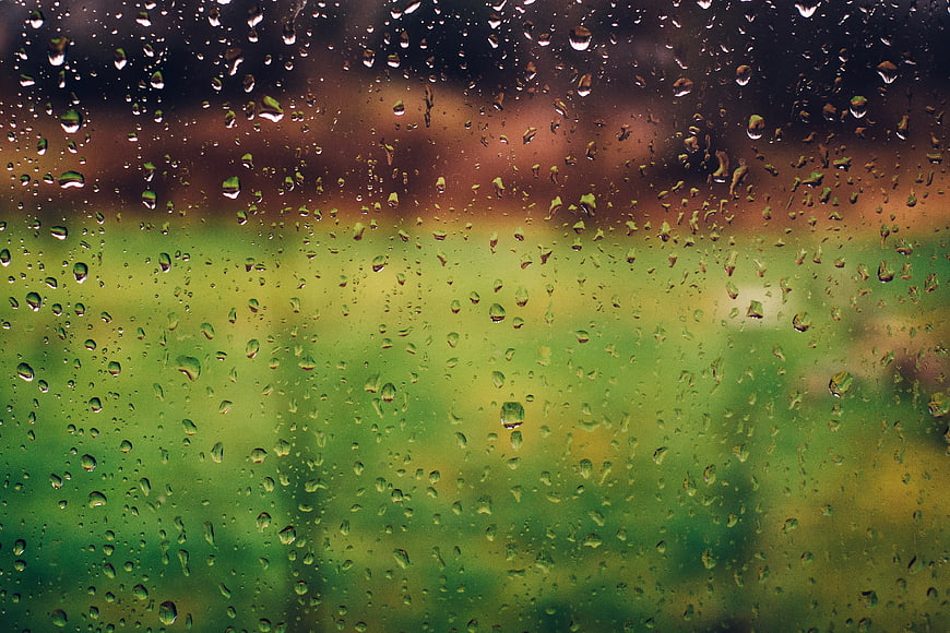 Raindrops on Window Glass with Blurred Green Background