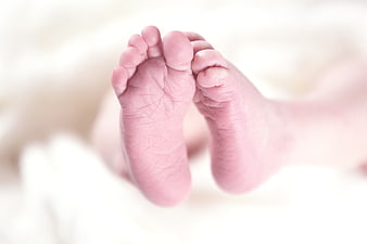 Close-up of newborn baby feet on white blanket