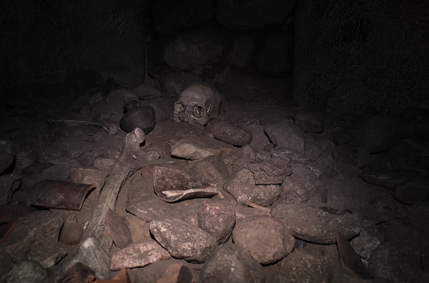 Human skull and bones in dark cave ruins