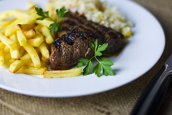 Grilled Steak with French Fries and Coleslaw on White Plate