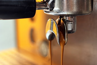 Close-up of espresso pouring from a professional coffee machine portafilter
