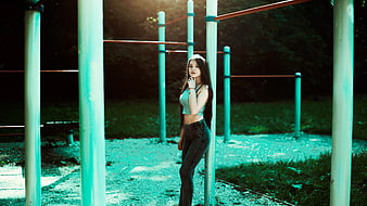 Woman Leaning on Green Metal Pole Holding Her Chin With Her Left Hand