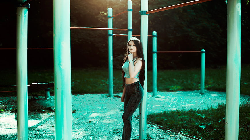 Woman Leaning on Green Metal Pole Holding Her Chin With Her Left Hand