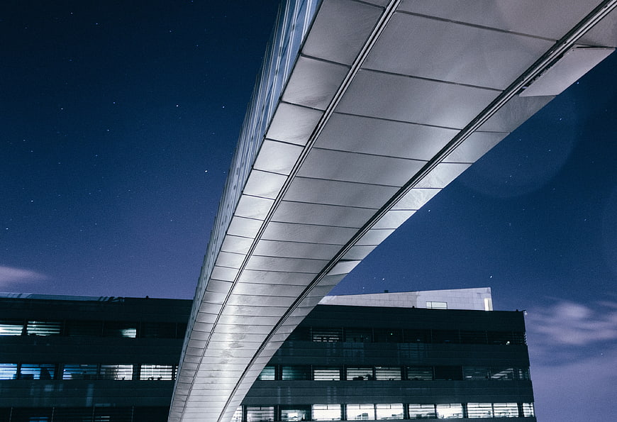 Modern curved bridge architecture against starry night sky