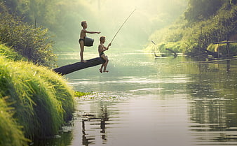Two young boys fishing from a log in a river