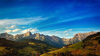 Scenic Alpine Mountain Landscape with Green Hills and Blue Sky