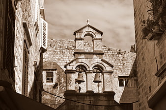 Sepia-toned church bell tower in historic stone city