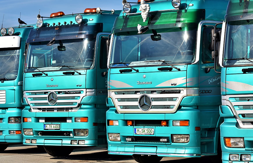 Row of Teal Mercedes-Benz Trucks Parked in a Line