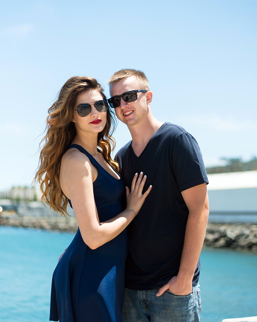 Young couple in love wearing sunglasses by the sea