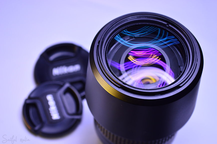 Close-up of camera lens with colorful light reflections