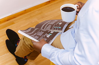 Man reading business magazine with coffee